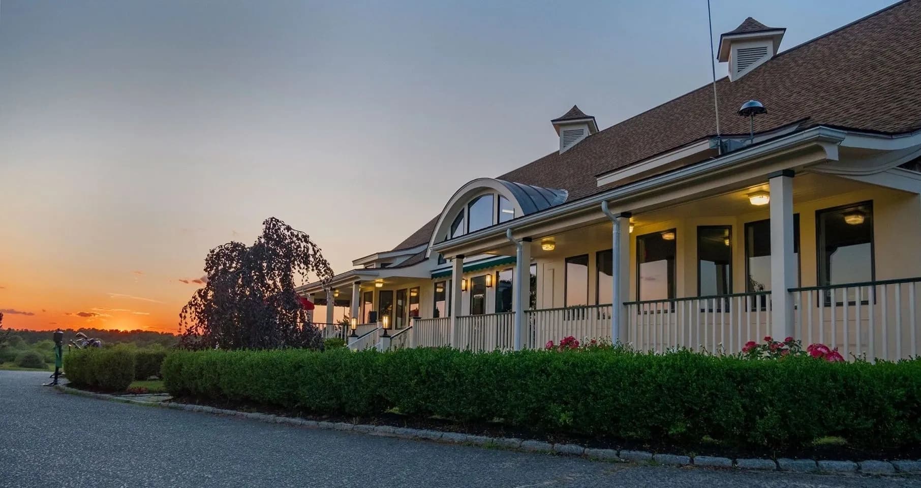 The Tavern on the Green exterior at sunset with warm porch lighting